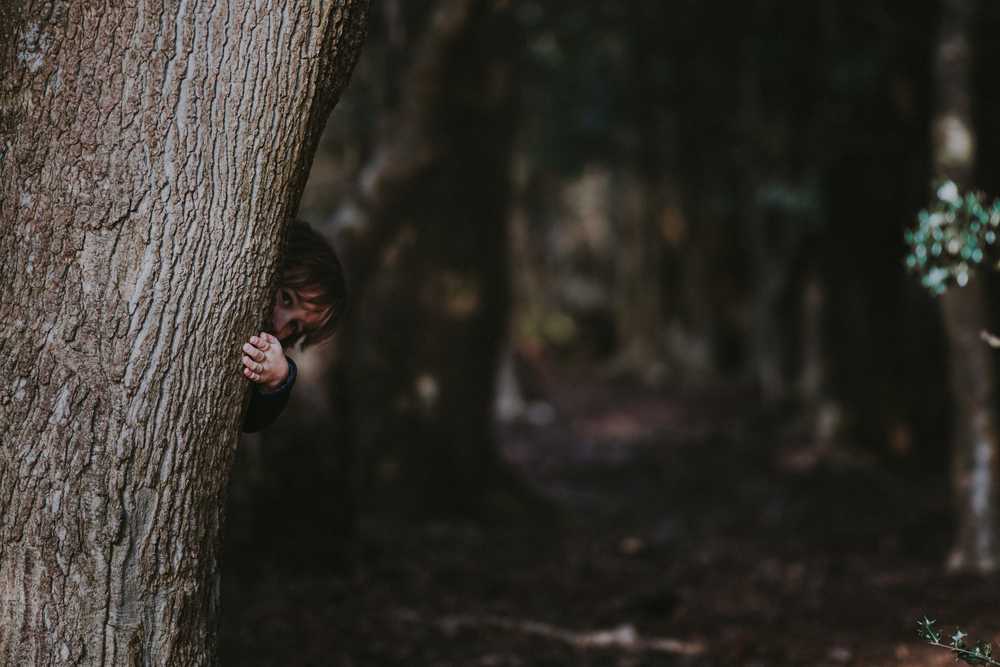 Child Hiding Behind Tree